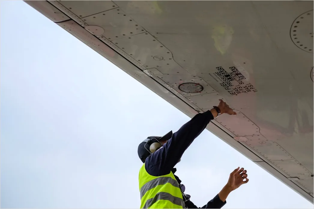 Detail Aircraft Maintenance Engineer Inspecting Engine Number 12