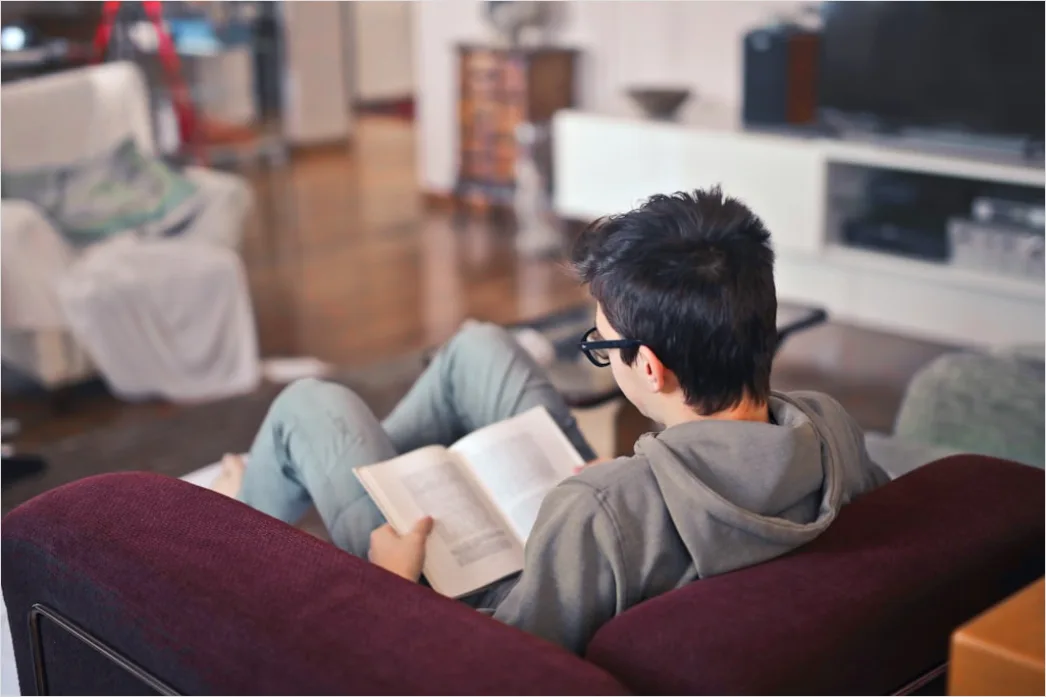 Detail Schüler Liest Schulbuch Auf Sofa Gemütlich Foto Number 2