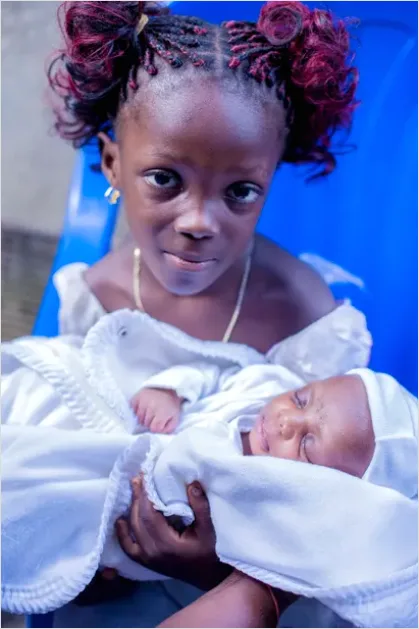 Detail New Big Sibling Holding Newborn Gently Number 3