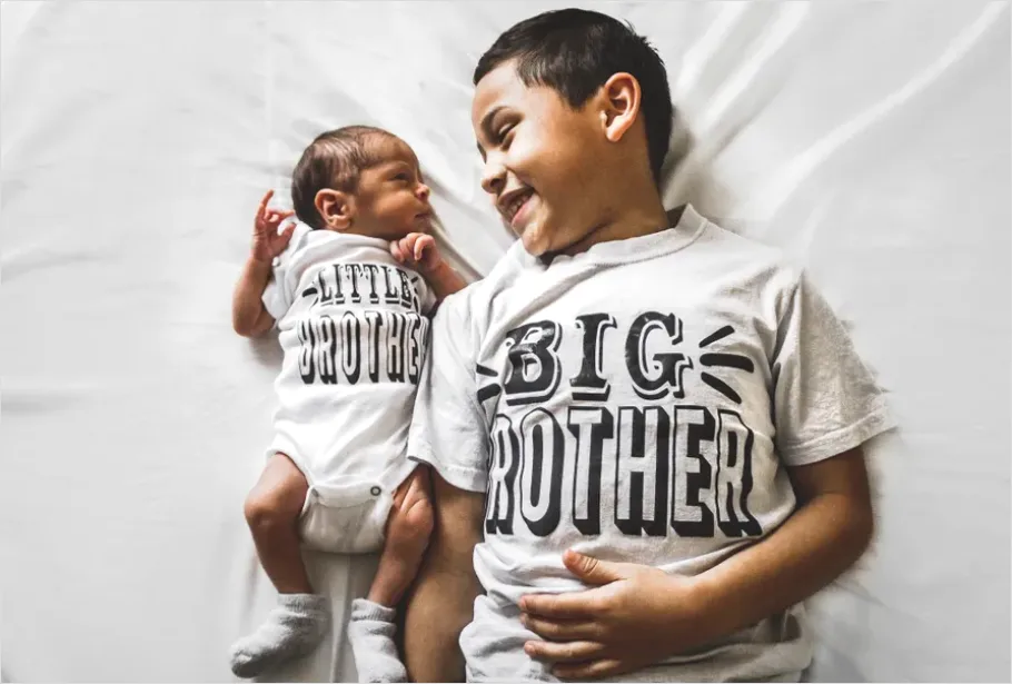 Detail New Big Sibling Holding Newborn Gently Number 5