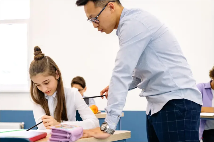 Detail Teacher Helping Student In Classroom Number 2