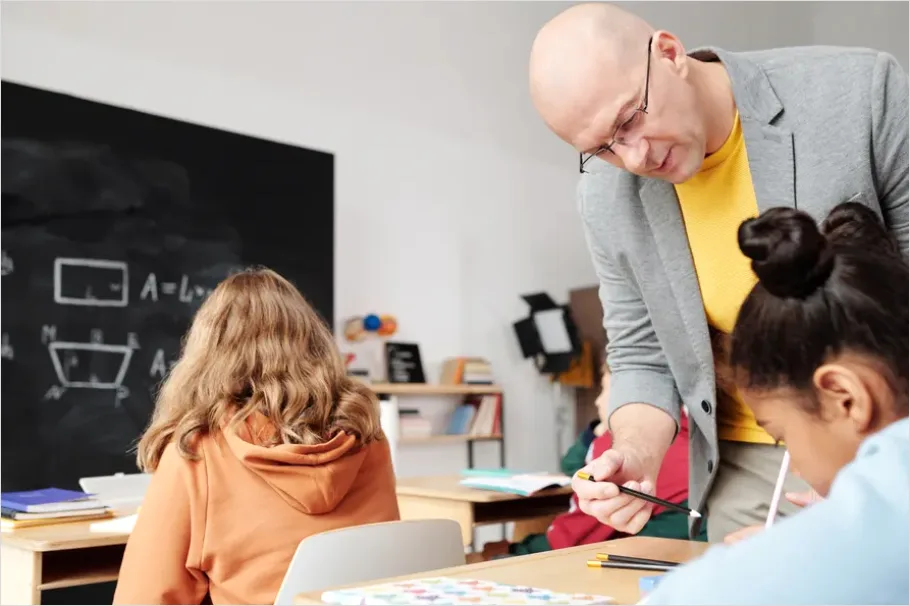 Detail Teacher Helping Student In Classroom Number 12