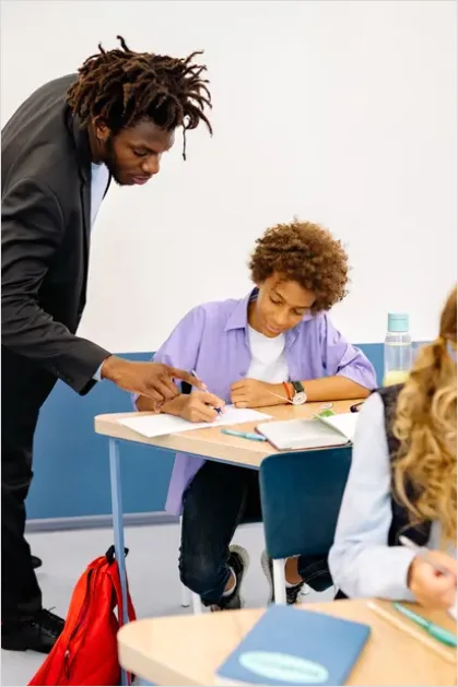 Detail Teacher Helping Student In Classroom Number 13