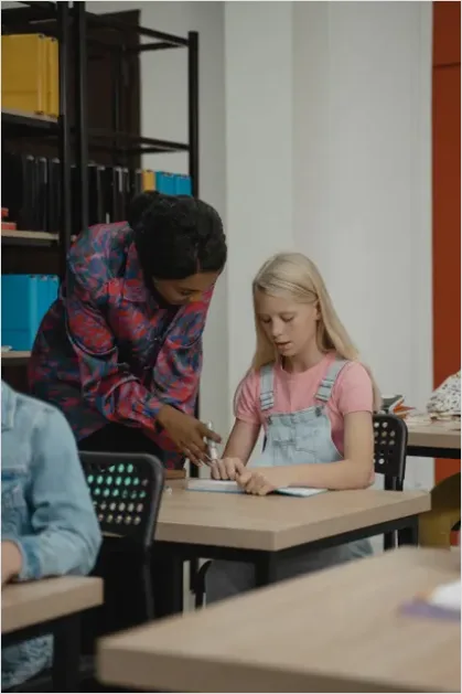 Detail Teacher Helping Student In Classroom Number 16